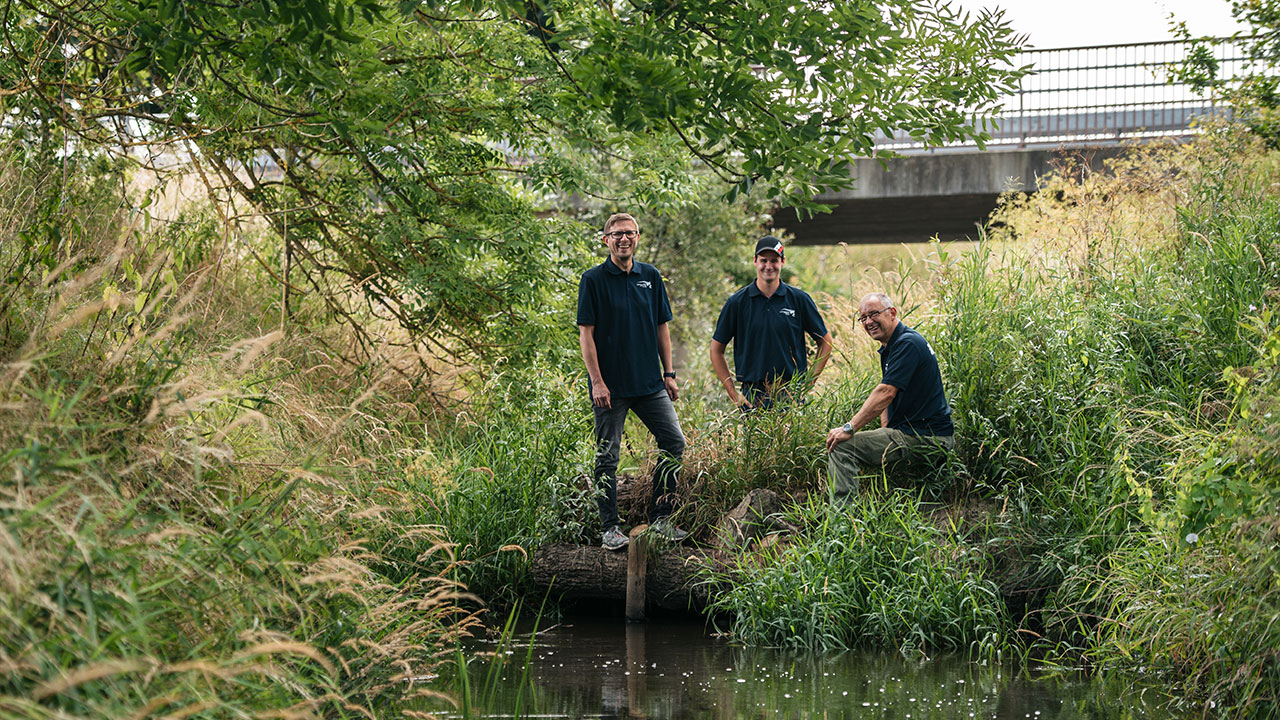 So sieht ein Strömungslenker aus natürlichen Materialien aus. Nils Sanne, Remo Fahr und Uwe Reinhold von der Flussmeisterei Borna an der renaturierten Wyhra (Foto: © Landestalsperrenverwaltung Sachsen / Fotograf Robert Lohse)